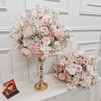 Centres de table floraux élégants roses et blancs sur un support doré, idéaux pour les mariages et événements romantiques.