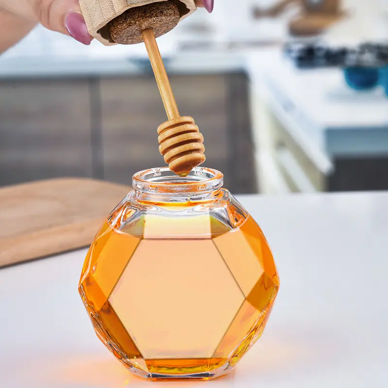Frasco transparente do mel do vidro do frasco do mel com a colher de madeira e a cortiça apropriadas para a cozinha home