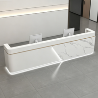 Bureau d'accueil moderne sur mesure effet marbre avec accents métalliques et éclairage LED pour bureau d'entreprise ou hôtel
