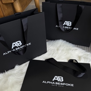 ถุงกระดาษสีดำแบบกำหนดเอง Alpha Bespoke พร้อมหูหิ้วริบบิ้น ใช้ซ้ำได้ หรูหรา สำหรับแชมพู มาสคาร่า พิมพ์ลายด้วยเทคนิคซิลค์สกรีน - Product Image 1