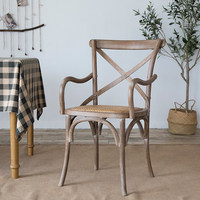 Chaise de restaurant à dossier croisé avec structure en bois et accoudoirs, siège rembourré en rotin