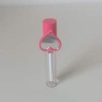 Tubo cilíndrico para brillo labial con tapa en espiral, etiqueta en forma de corazón rosa, material plástico