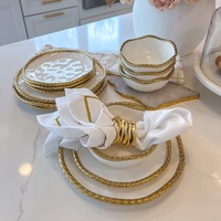 Service de table luxueux en céramique avec bordure dorée, assiettes, assiettes à fruits et à pâtisserie, assiettes à steak pour dîner occidental en hôtel.