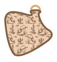 Bavoir en forme de vache avec imprimé chapeau de cowboy sur toute la surface, base bleu clair et anneau en bois, bavoir bébé western simple.