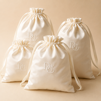 Pochette à bijoux en satin lisse avec cordon de serrage, emballage cadeau avec détail monogramme pour les détaillants de boutiques et les marques de bijoux