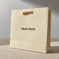 Emballage de vêtements cosmétiques avec logo personnalisé sac de vêtement à poignée découpée sacs en papier en carton de luxe à provisions pour petites entreprises