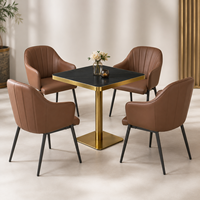 Ensemble table et fauteuils, surface en pierre frittée noire avec base en piédestal doré, mobilier pour café, terrasse et véranda