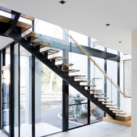 Escalier intérieur flottant droit en acier au carbone moderne nord-américain avec bande de roulement en bois et garde-corps en verre trempé