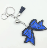 Koningsblauwe modieuze sleutelhanger met zwarte achtergrond, strikvorm, volledig bezet met strass steentjes en kwastjes, best verkochte charme hangende ornament