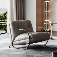 Fauteuil lounge luxueux rembourré avec structure en métal finition laiton courbé et accents en cuir capitonné pour salon, hôtel, villa