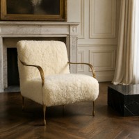 Fauteuil de salon sculptural avec accoudoirs en métal doré et pieds coniques pour salons et suites d'hôtel