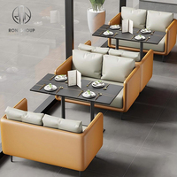 Ensemble de mobilier de café moderne, restaurant, canapé gris avec garniture orange, tables rectangulaires grises et chaises orange