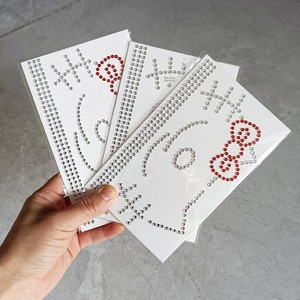 Pegatinas de tatuaje facial de Hello Kitty transfronterizas, hechas a mano con diamantes de imitación, maquillaje de Año Nuevo, decoraciones de diamantes de imitación con purpurina en tarjeta blanca. - Product Image 5