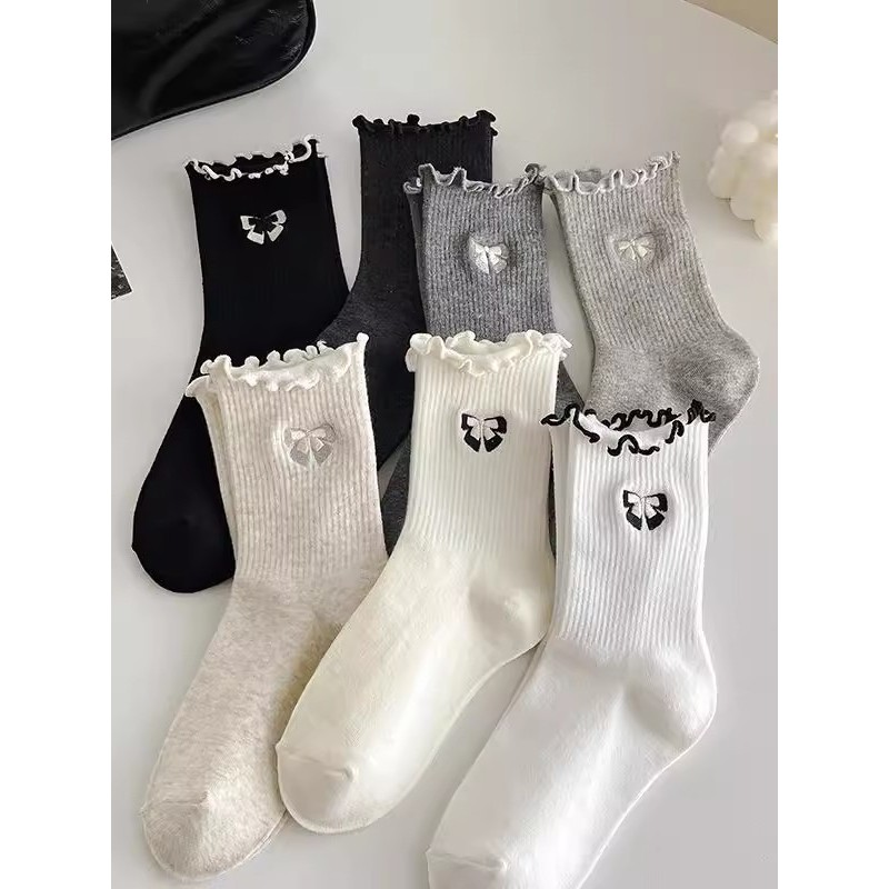 Women's mid-length tank top with ruffled trim and bow.