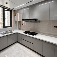 Meuble de cuisine sans poignées, gris brillant, configuration d'angle avec unités murales complètes pour projets de rénovation d'appartements et de condos modernes