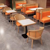 Ensemble de mobilier de restaurant moderne : canapé en cuir orange incurvé, table en marbre, chaises à cadre en rotin tressé – Idéal pour les hôtels et salles à manger durables