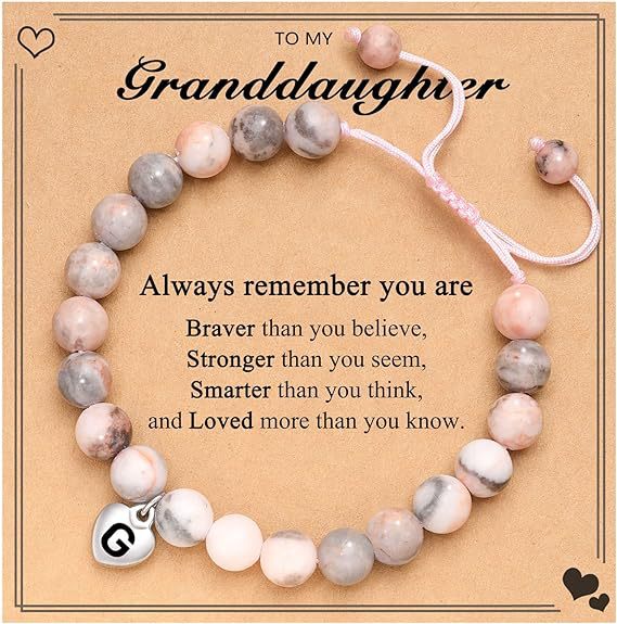 Pulsera rosa tejida con diseño de cebra y letra G.