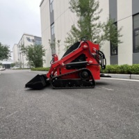 Chargeuse compacte sur chenilles en stock, prête à l'emploi, avec râteau et marteau hydraulique pour la réparation des chemins de jardin et de village