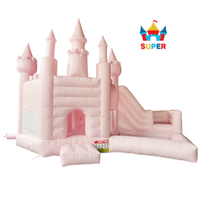 Château gonflable rose sur le thème des princesses avec piscine à balles, aire de jeux extérieure pour enfants.