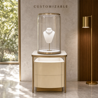 Table de présentation de bijoux en verre incurvée aux coins arrondis, corps beige, cadre en métal brossé doré pour magasin de détail et vente en gros