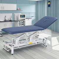 Table de massage électrique portable réglable en hauteur en acier inoxydable avec revêtement en PU et système de repose-pieds pliable pour traitement professionnel