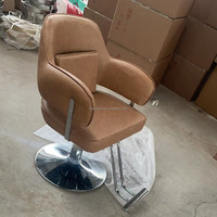 La chaise de barbier marron est livrée avec le même oreiller et la base ronde argentée est stable et porteuse