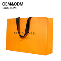 Sac shopping de luxe en papier orange avec poignée en ruban, logo gaufré or, entièrement personnalisable, emballage promotionnel écologique