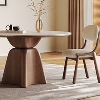 Table à manger ronde élégante avec surface lisse et base sculpturale en bois