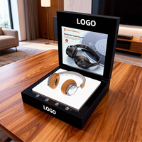Un présentoir interactif à écran LED en acrylique noir qui met en valeur intelligemment les écouteurs supra-auriculaires avec un éclairage d'ambiance.