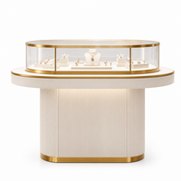 Vitrine à bijoux ovale moderne en verre avec base rainurée et surface incurvée éclairée par LED