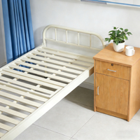 Lit médical manuel fixe pour soins à domicile et hôpital, avec cadre en tubes d'acier, capacité 240 kg, crochets IV réglables pour drainage en salle.