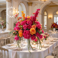 Centre de table floral artificiel éclatant, fleurs rose vif et orange, idéal pour la décoration de tables de mariage et les événements de banquet.