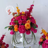 Centre de table floral artificiel éclatant, fleurs rose vif et orange, idéal pour la décoration de tables de mariage et les événements de banquet.