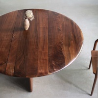 Table à manger ronde en noyer massif de style Mid-Century, avec trois pieds en dalle et piétement croisé, idéale pour studio ou loft