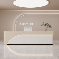 Bureau d'accueil incurvé minimaliste sur mesure avec panneau frontal ondulé cannelé et éclairage LED pour salon de beauté, spa, boutique de vêtements