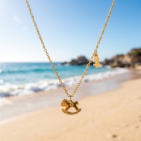 Collier pendentif QIAOREN 13811 avec chaîne fine à maillons ovales, breloque cheval à bascule gravée et mini signe dollar sur le côté