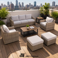 J&M T823 Ensemble de mobilier d'extérieur pour terrasse urbaine en fer et rotin PE, comprenant canapé profond, fauteuils et ottomanes, et table à effet bois avec structure en fer