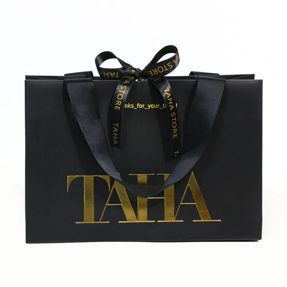 Il regalo personalizzato della Boutique in lamina d'oro trasporta sacchetti di carta neri con manici papillon a nastro bolsa de papel