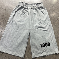 Shorts amples en molleton à jambes larges avec logo personnalisé, ourlet effiloché, taille élastique à volants, empiècement à carreaux et poche arrière, style streetwear