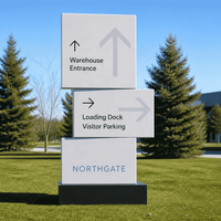 Panneau de signalisation directionnel noir monolithique avec flèches blanches pour la signalisation des campus d'entreprise