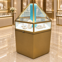Vitrine à bijoux contemporaine avec dessus en verre facetté, armoire en métal doré, panneau central bleu, éclairage LED pour les magasins de bijoux de marque