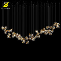 Lustre LED artistique en boules de verre - Suspension cascade dorée pour hall d'hôtel et atrium