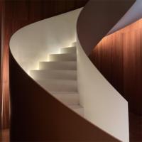 Escalier moderne incurvé en bout Structure en bois et acier avec rail en verre design pour maisons duplex à usage intérieur Aménagements ouverts