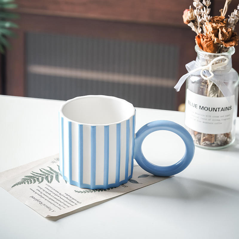 ถ้วยลายทางแนวตั้งสีน้ำเงินและสีขาวพร้อมหูจับทรงกลม