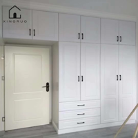 Armoire blanche sur mesure XINGRUO avec portes à panneaux surélevés, poignées noires, tiroirs et rangement pleine hauteur