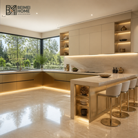 Meubles de cuisine modernes sur mesure couleur champagne, blanc cachemire, avec éclairage intégré, péninsule, bar et armoires de style manoir
