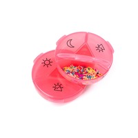 Boîte à pilules ronde en plastique rose avec des icônes soleil et lune pour le rangement des médicaments