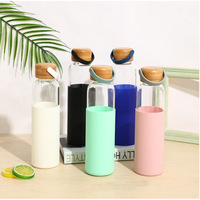 Botol air kaca bening pesanan mendesak dengan lengan silikon dan tutup bambu pengiriman cepat