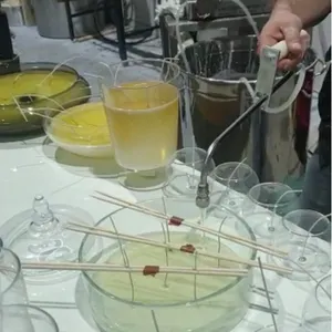 Una persona aziona la macchina di fusione della cera di soia del macchinario della candela con l'attrezzatura di riempimento di colata della paraffina dell'esposizione di temperatura Yide