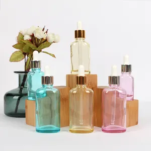 Bottiglia cosmetica in vetro oblato trasparente che imballa olio essenziale per capelli con contagocce in alluminio dorato